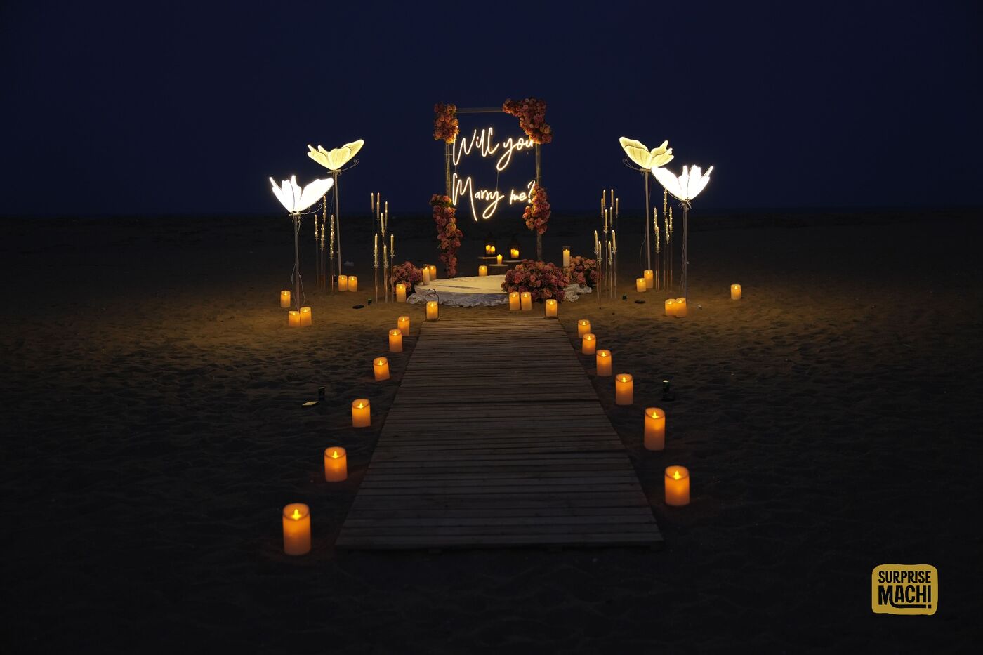 Candlelit beach proposal walkway at night