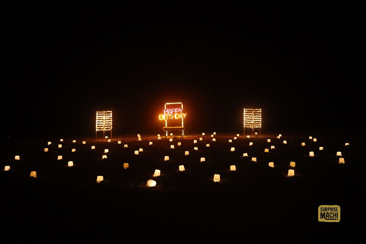 Happy Birthday beach surprise with paper lanterns at night